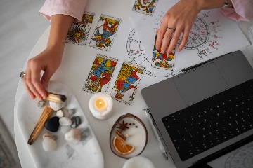 Pessoa observando cartas de tarot em uma mesa durante uma leitura, representando os erros a evitar