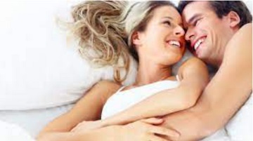 Casal de m&atilde;os dadas diante de n&uacute;meros e s&iacute;mbolos de numerologia em tons de rosa e dourado