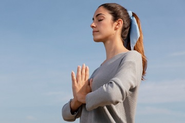 Pessoa meditando em posi&ccedil;&atilde;o de l&oacute;tus, representando a pr&aacute;tica de Kundalini Yoga