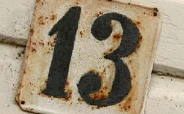 Rel&oacute;gio antigo marcando treze horas, ao lado de um calend&aacute;rio com a data de uma sexta-feira 13